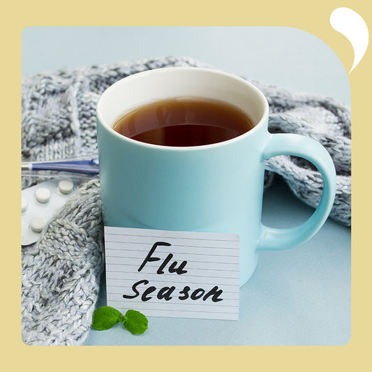 a cup of punch and a pill on the table with a card that says flu season
