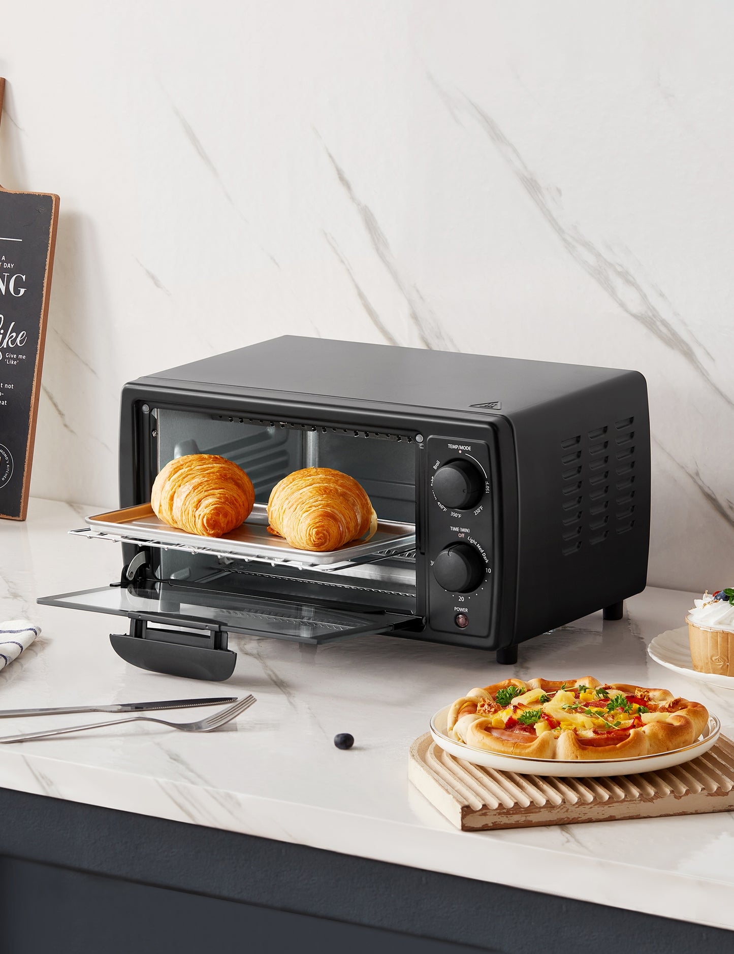 black comfee toaster oven behind a plate of food and cutlery