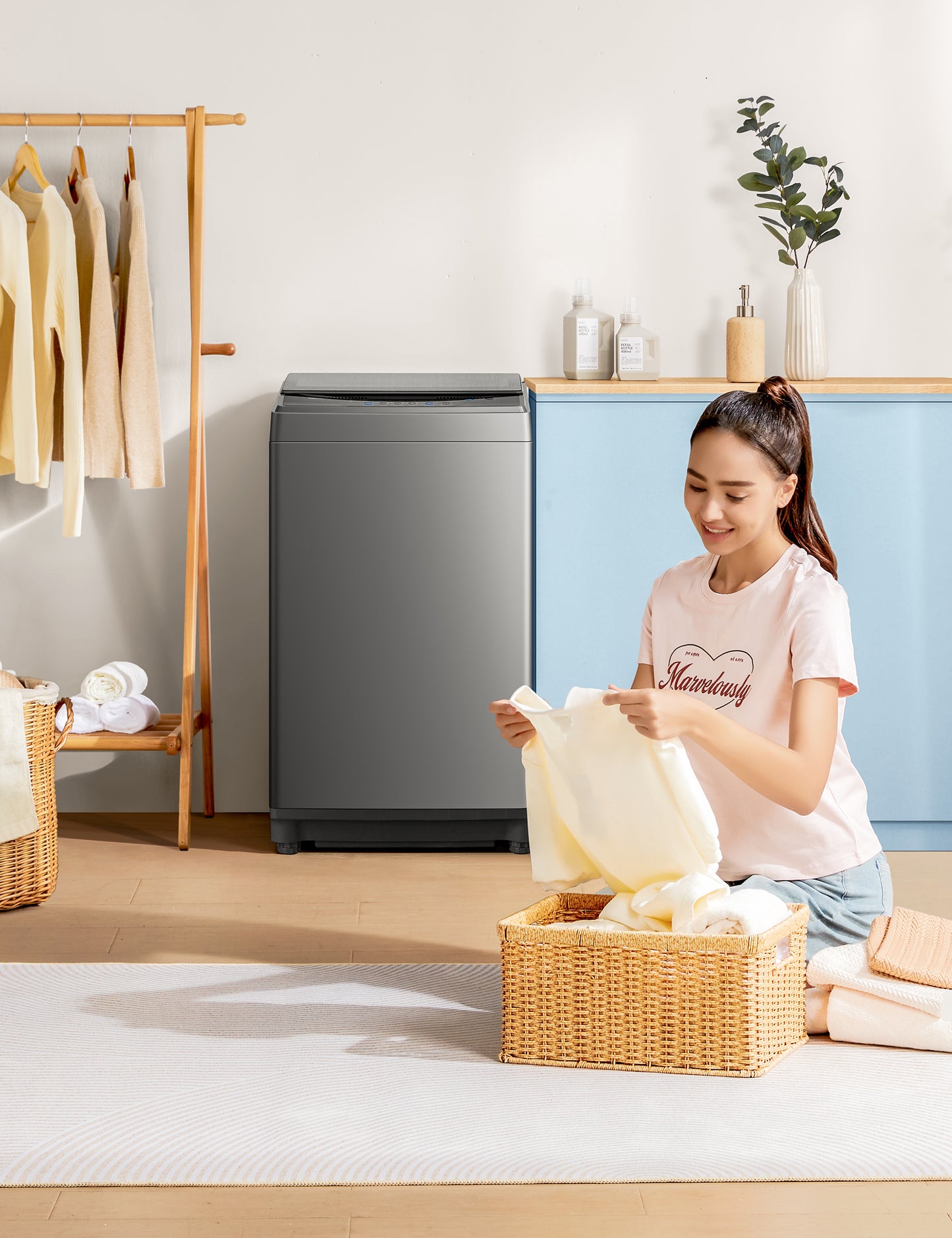 someone folding clothes near comfee washing machine