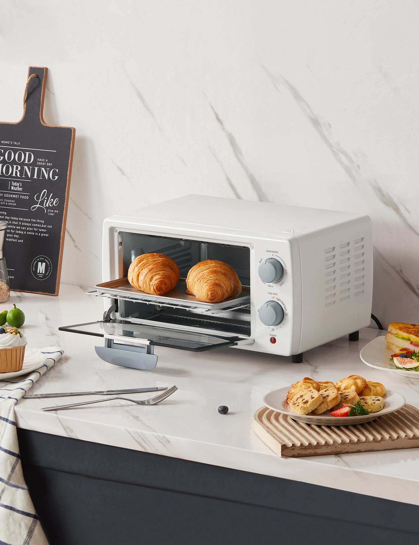 comfee toaster oven behind a plate of food and cutlery