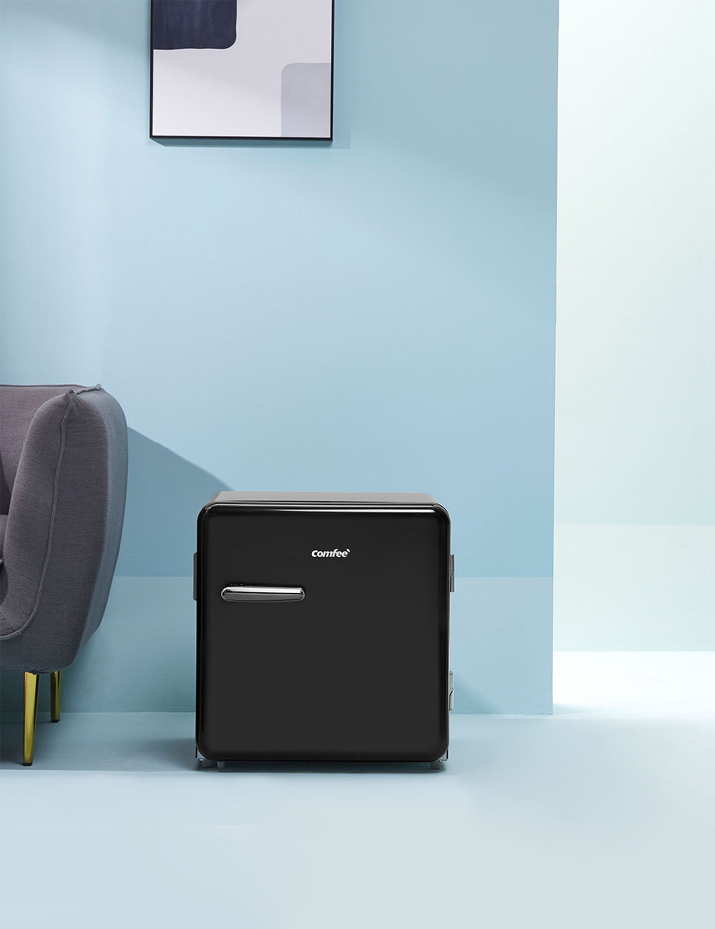 black comfee mini fridge in a modern blue interior next to a grey couch