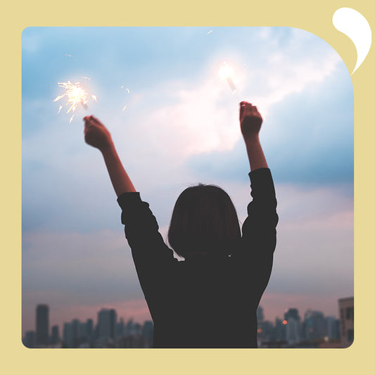 A woman waving a fireworks stick with both hands