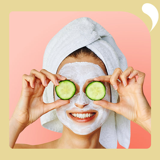 the woman smiled and held up two cucumber slices to her eyes