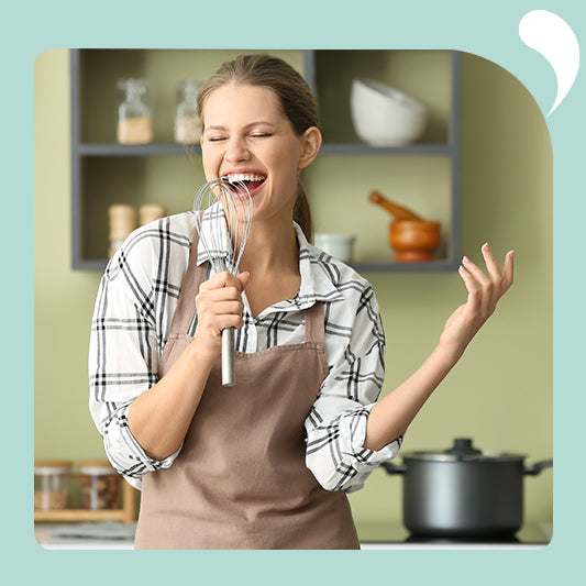 A woman singing in the kitchen.