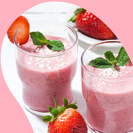 two glasses of pink smoothies and a plate of plate of strawberries