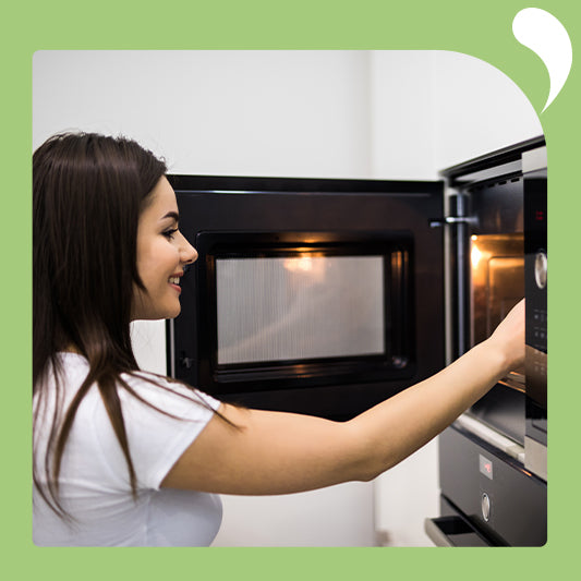 The young woman smiled as she looked at the food in the microwave.