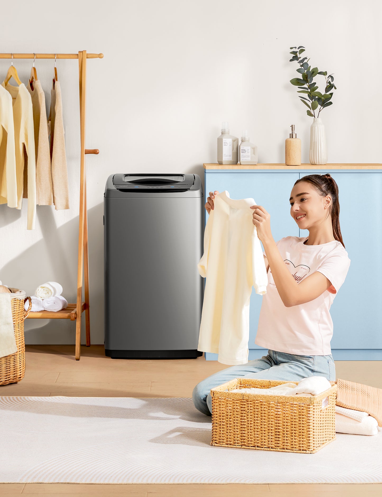 someone folding clothes near comfee washing machine