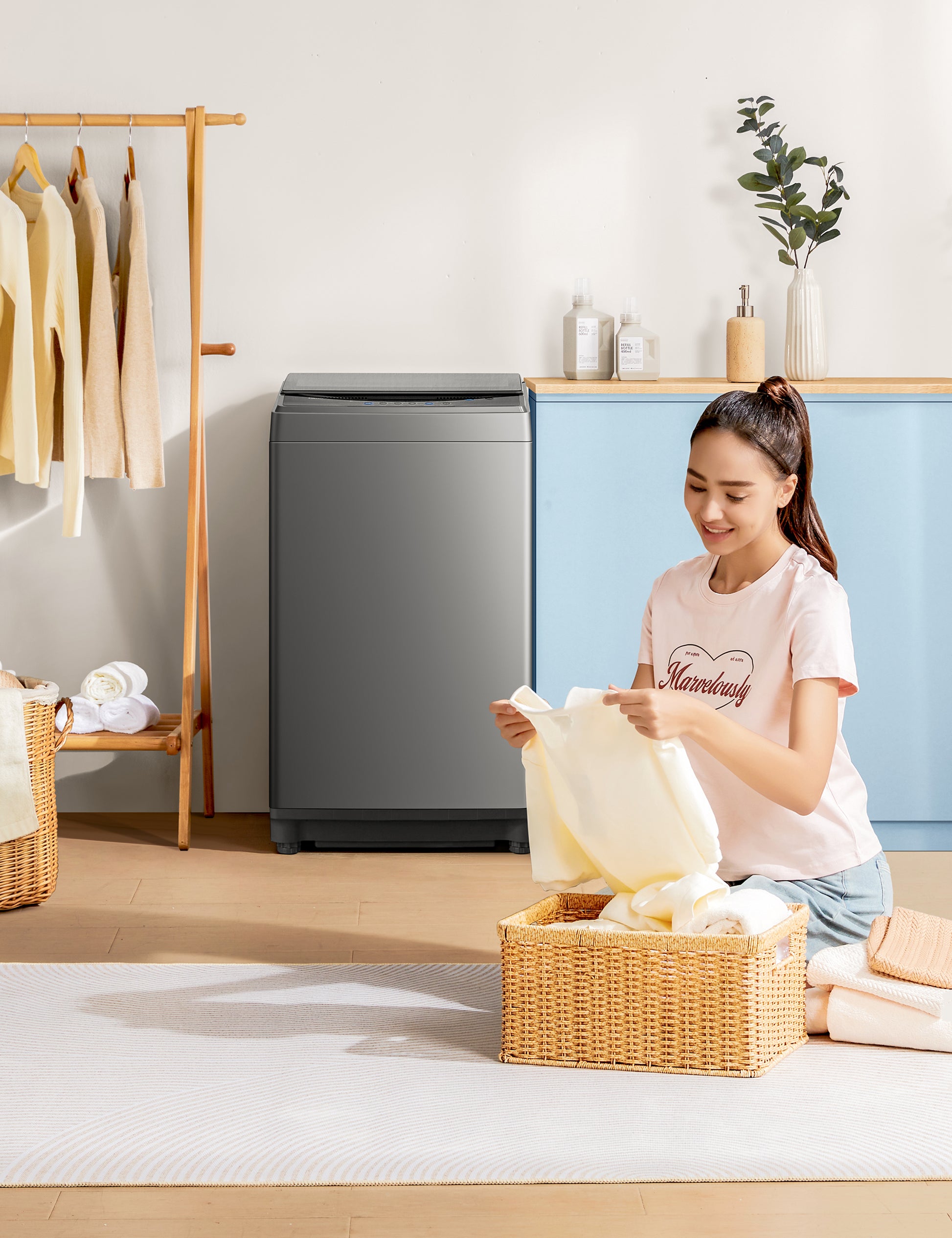someone folding clothes near comfee washing machine