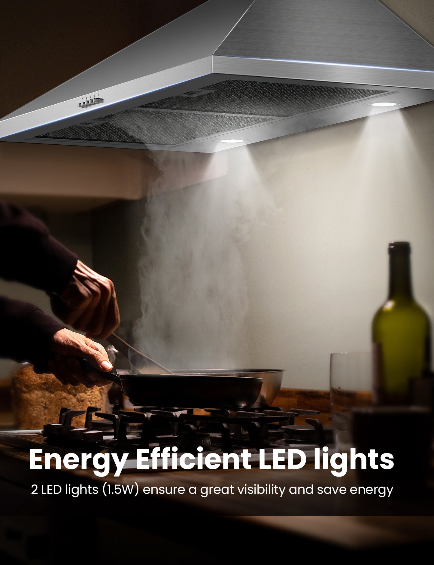 a man cooking food in the dark under a ducted range hood with its led lights on