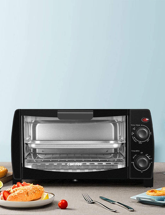 black comfee toaster oven behind a plate of food and cutlery