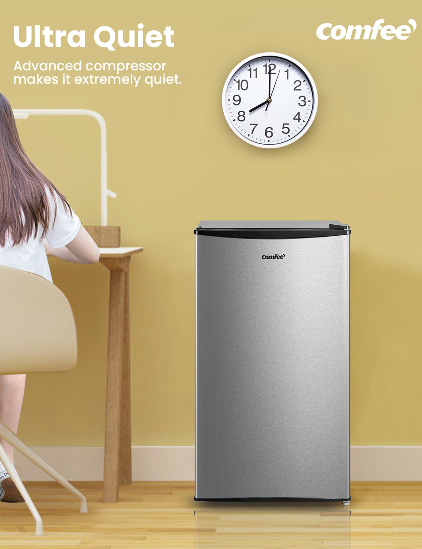 comfee compact refrigerator next to woman sitting at a desk