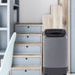 grey portable washing machine in modern interior next to a staircase