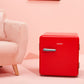 red mini comfee retro fridge on the floor in a stylish interior