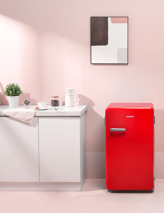 red comfee compact refrigerator in a stylish pink interior
