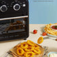 a plate of onion rings and fries in front of a retro style air fryer toaster oven