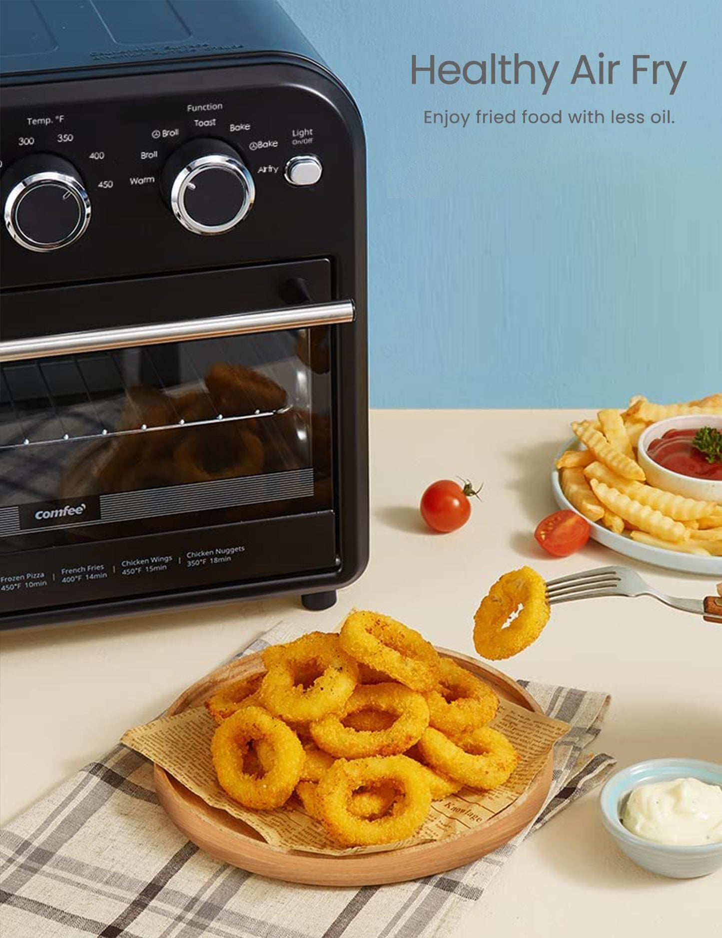 a plate of onion rings and fries in front of a retro style air fryer toaster oven