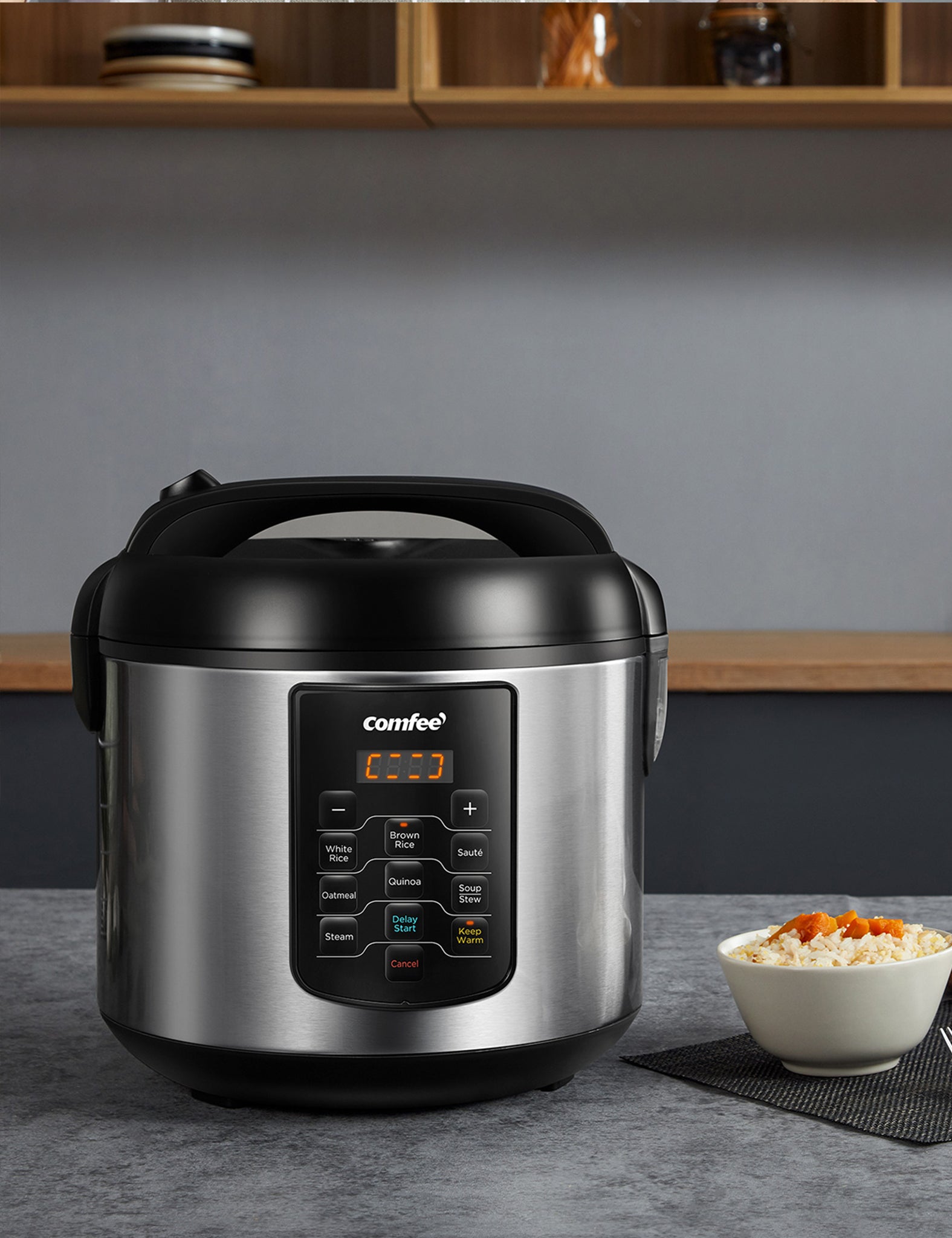 comfee stainless steel rice cooker next to a bowl of rice