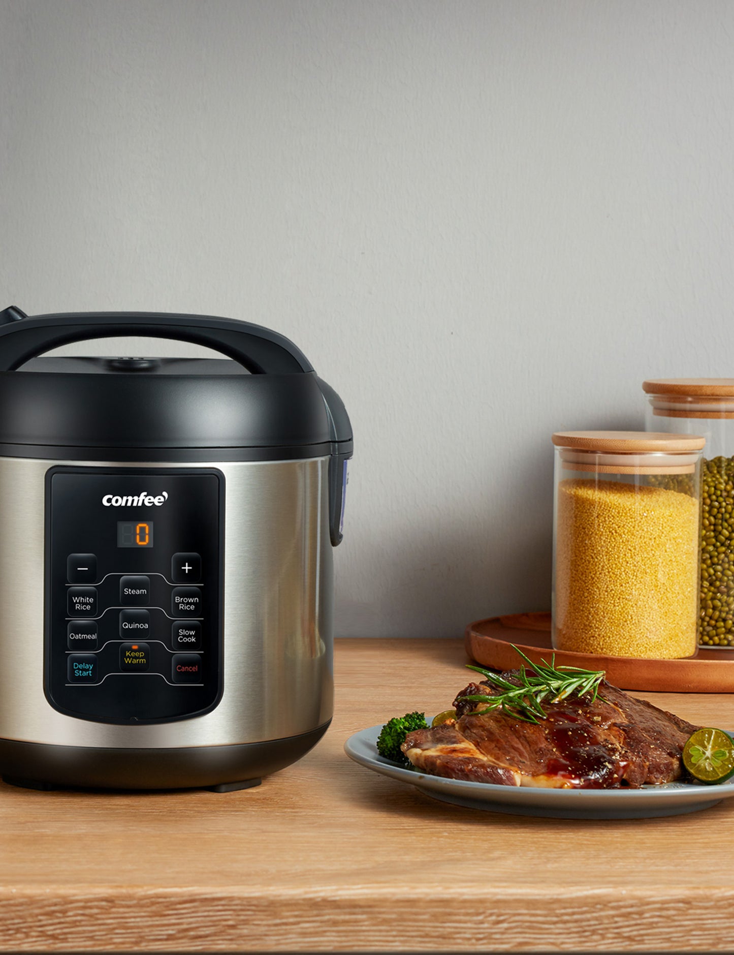 stainless steel comfee rice cooker next to a cooked steak on a plate