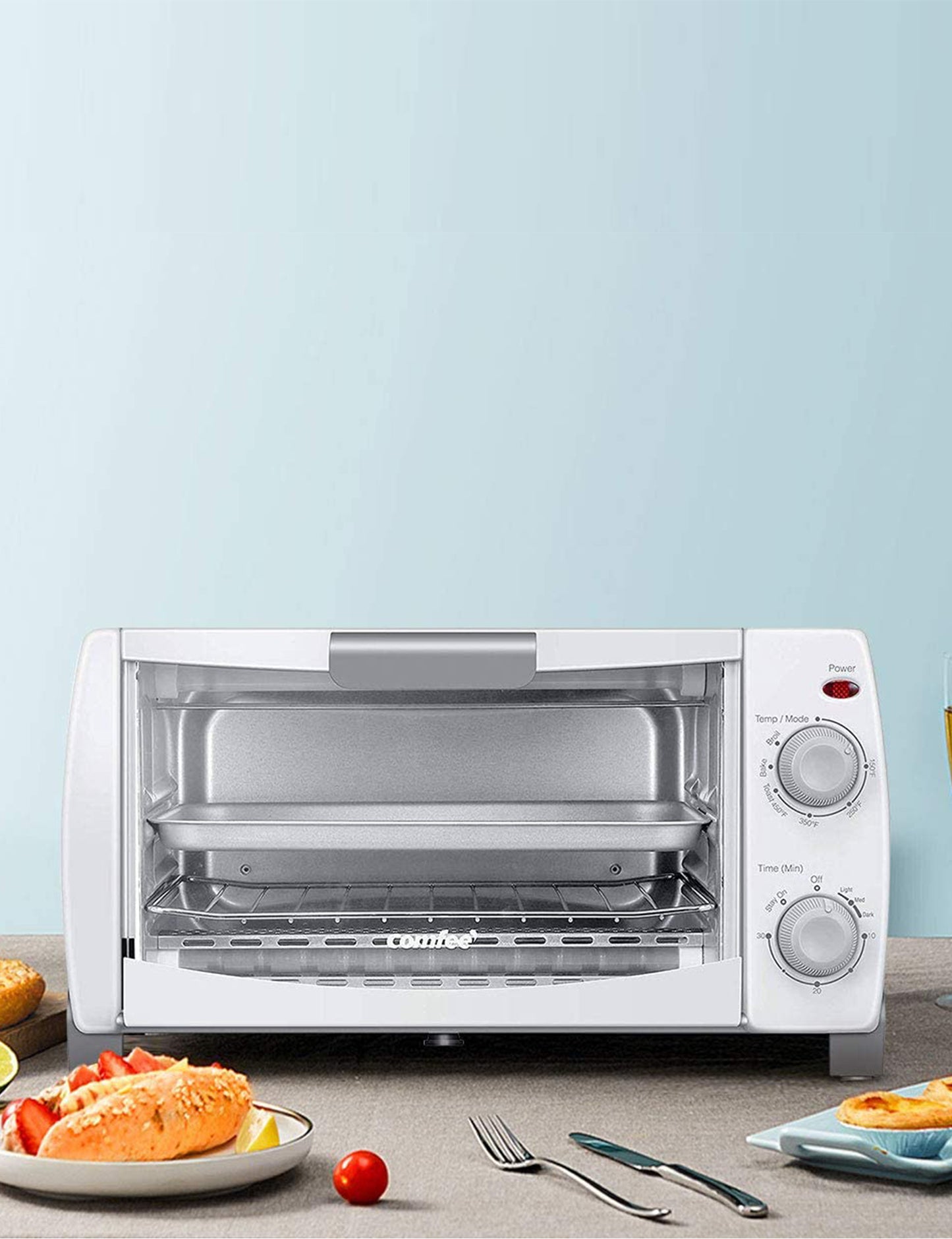 white toaster oven behind a plate of food knife and fork